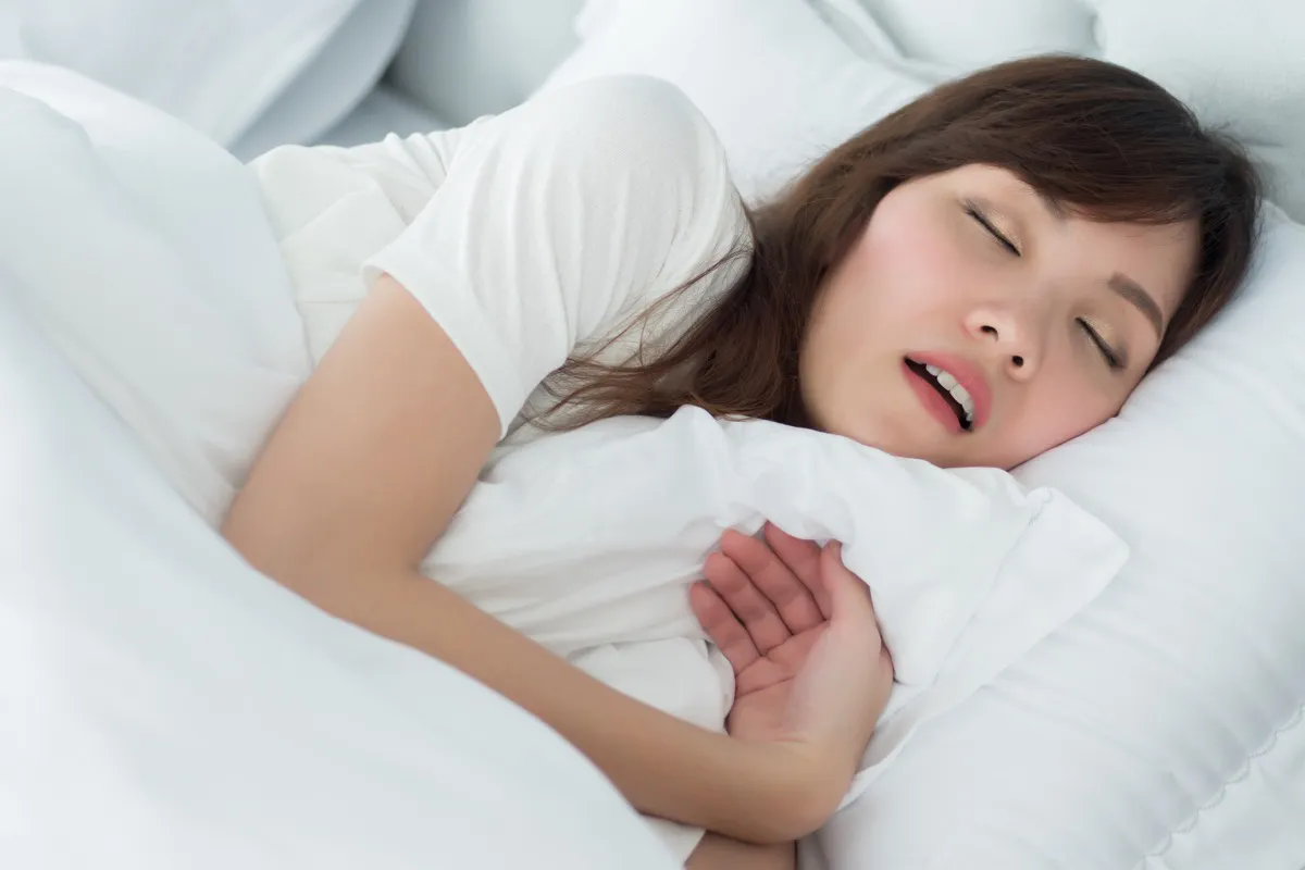 woman sleeping in bed with white sheets