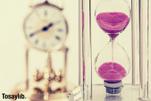 hourglass pink sand dripping clock blur background