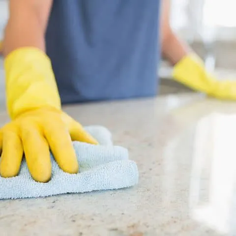 woman cleaning down the counter
