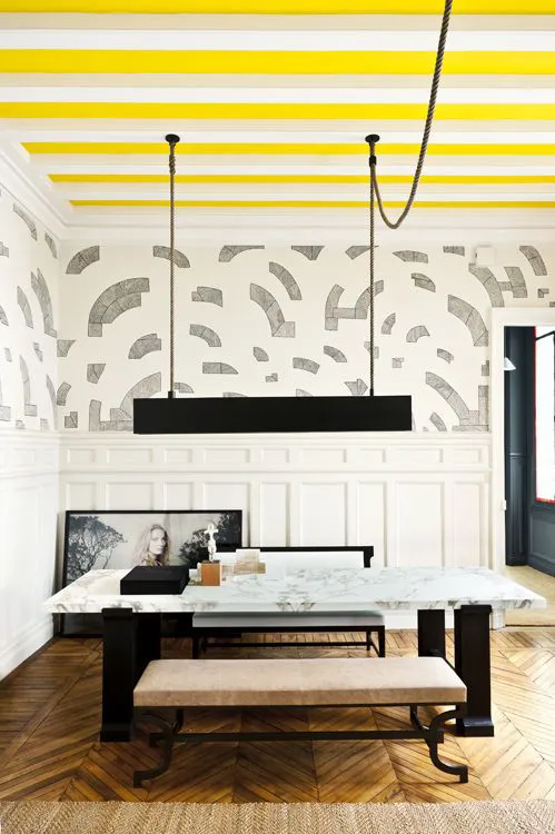 Stylish, modern dining room with ceiling painted in yellow stripes