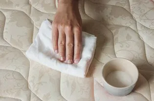 person blotting a mattress
